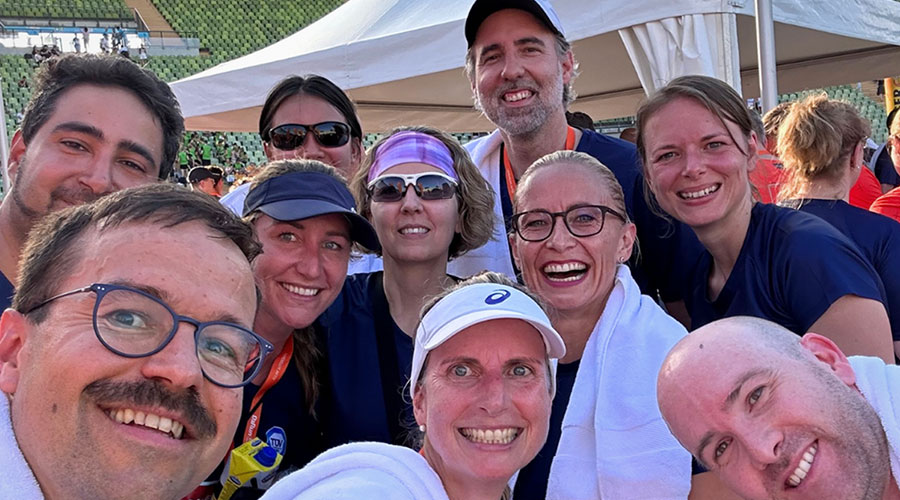 A group of people taking a happy selfie after participating in a running event together.