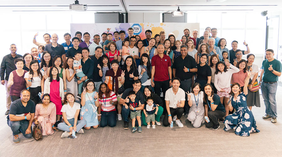 A large group of people posing together and smiling.